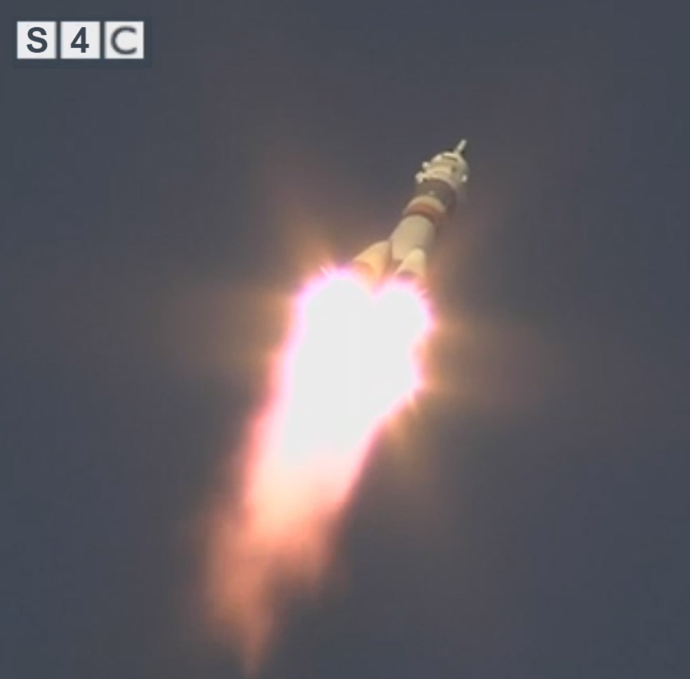 A Soyuz spaceship just launched against a dark sky.
