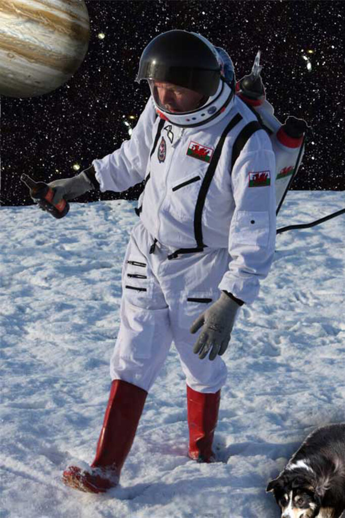 A man in a spacesuit and red wellied is seen staggering on a frozen snow field. He is holding an empty bottle of beer. Over the horizon Jupiter can be seen.