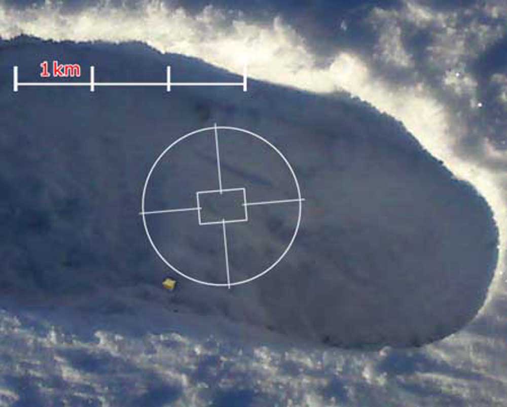 A snowy footprint with a map scale on it and a camera graticule. There is a small yellow dot near the bottom of the footprint indent.