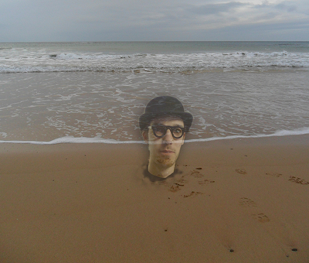 A transparent human head on a beach with the sea lapping up. The head is alive and wearing a bowler hat.
